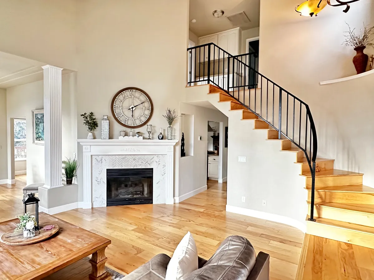 This image reveals a spacious, light-filled living area with a comfortable seating arrangement oriented around a fireplace. The presence of a large clock hints at timelessness and routine—ideal for a business traveler managing a busy schedule. The setting feels peaceful and encourages unwinding after a demanding day, while multiple seating options suggest flexibility for both relaxation and remote work.