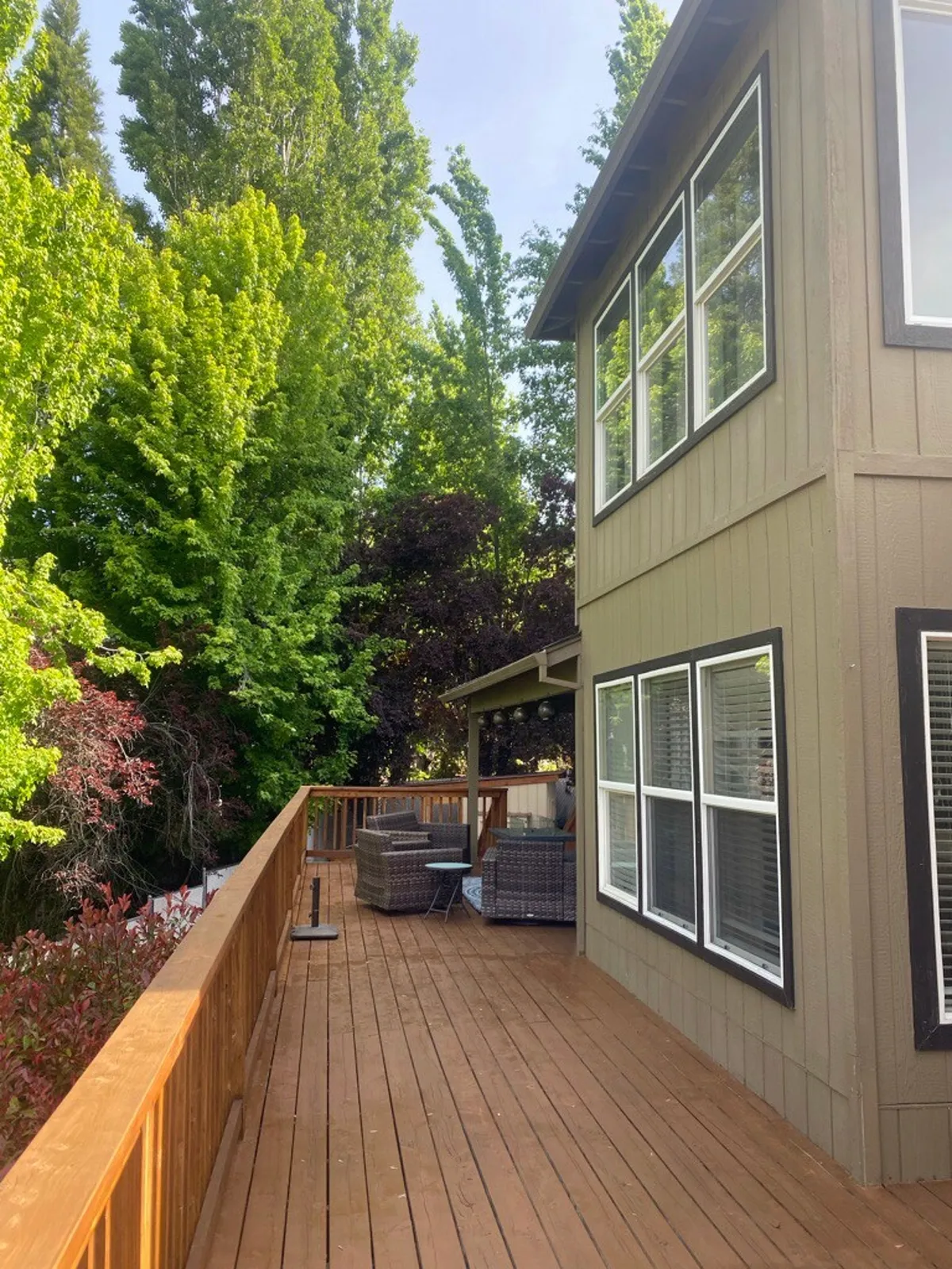 The image shows a tranquil deck surrounded by mature trees and furnished for outdoor relaxation or meals. The peaceful, nature-immersed setting is ideal for family gatherings and connects directly to the spirit of exploring parks and enjoying the outdoors.